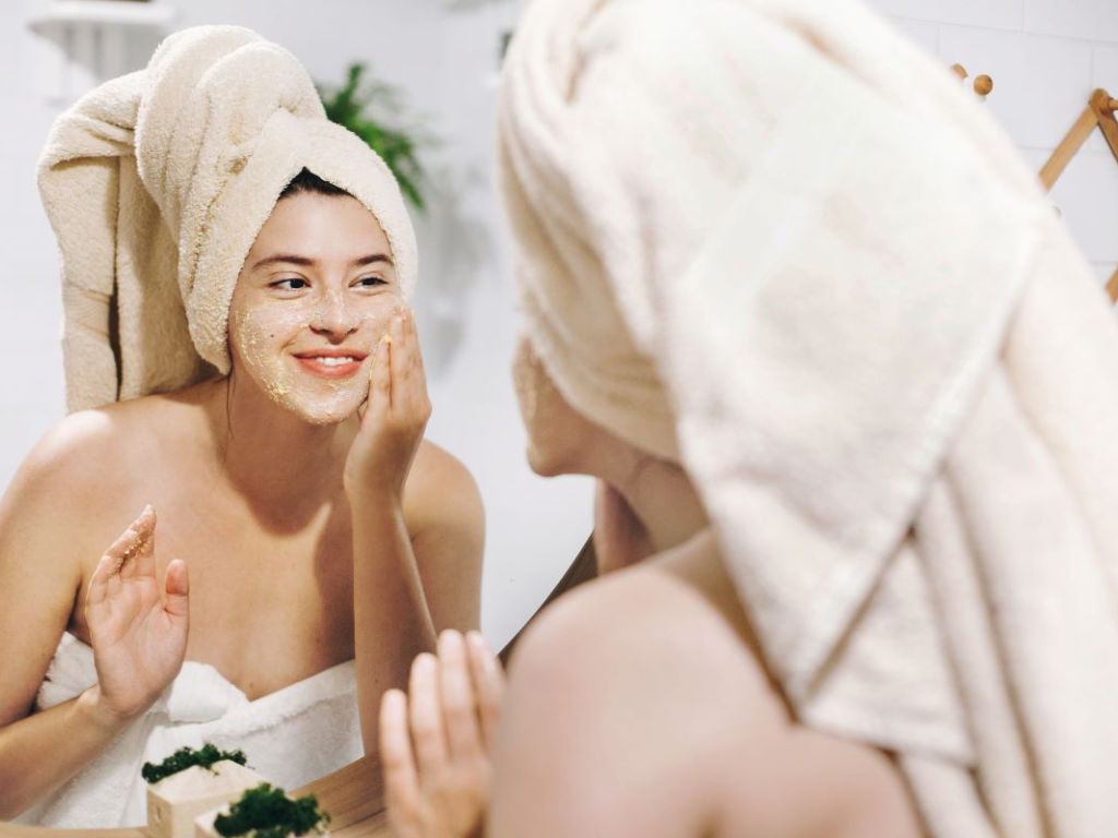 Woman in Towel Applying Skincare to Face
