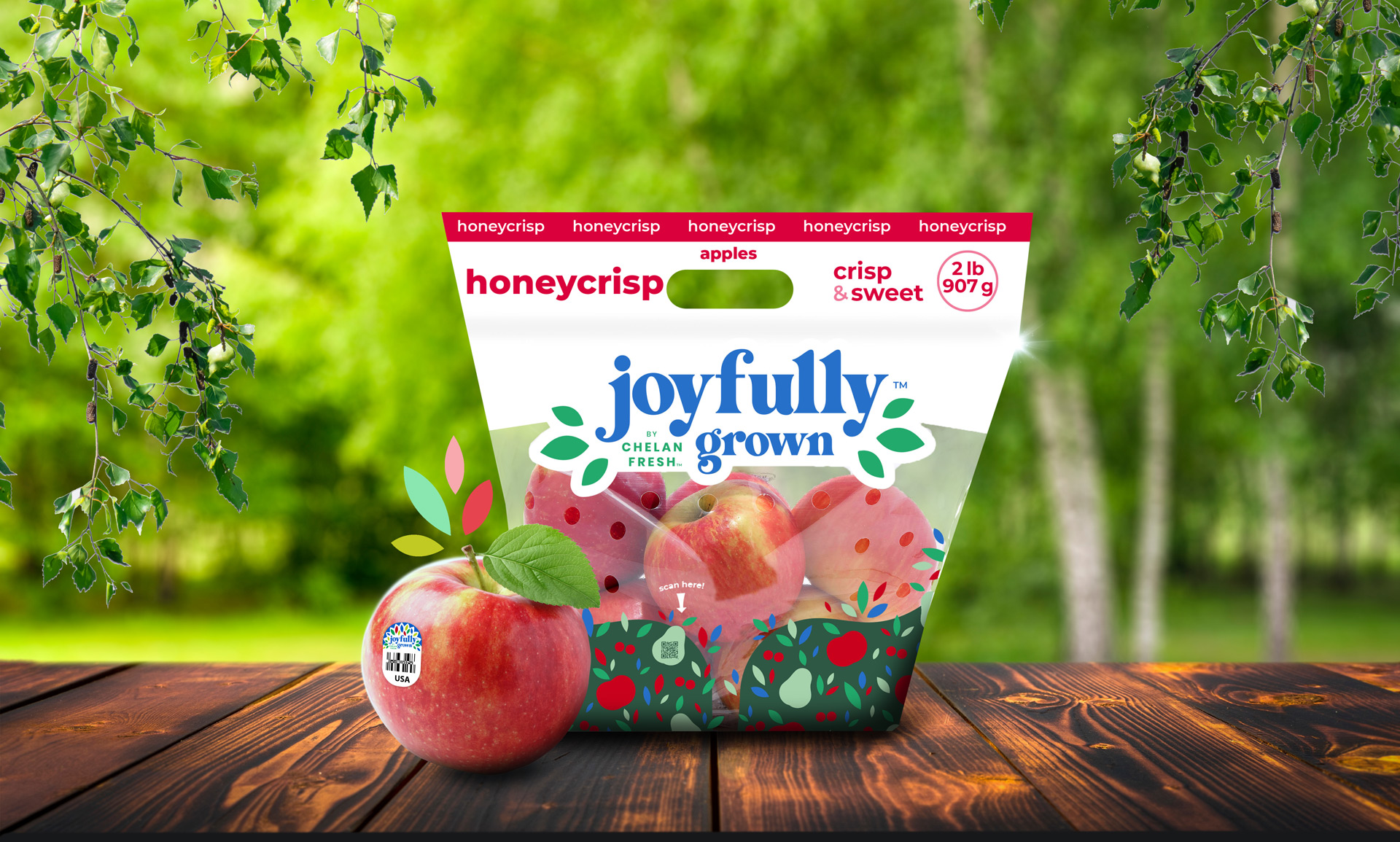 Joyfully Grown Honeycrisp Apple Packaging on Dark Wood Planks and a Blurred out Orchard in the Background