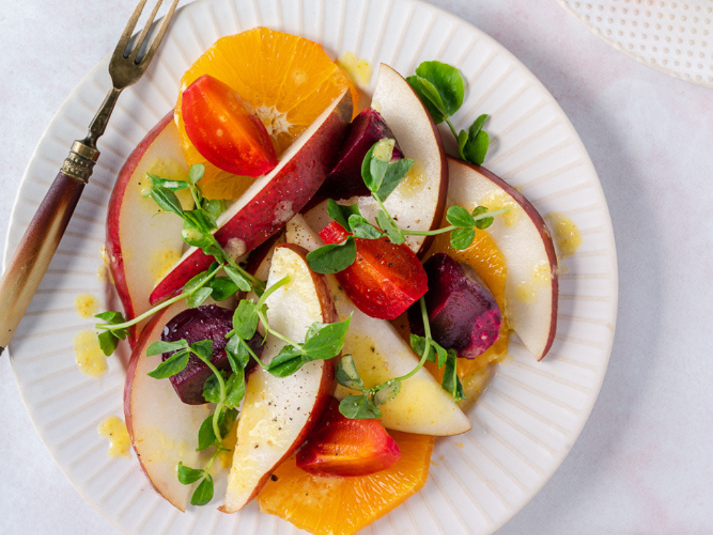 Starkrimson Pear Citrus Salad on a White Plate and Table Cloth with a Fork