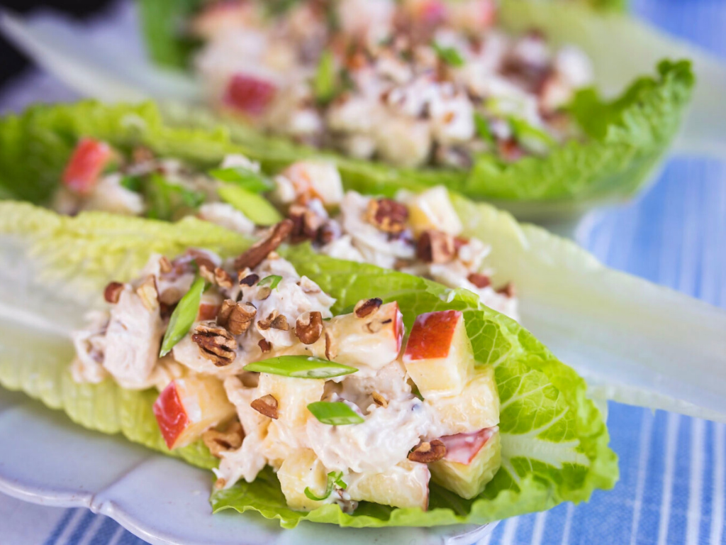 Apple Pecan Chicken Salad on Lettuce Leaves on a Blue and White Striped Tablecloth